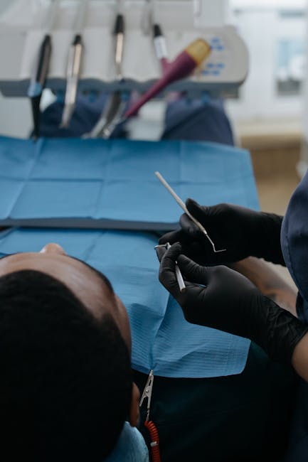 Dentist in black gloves performing dental checkup in a clinic setting with patient.